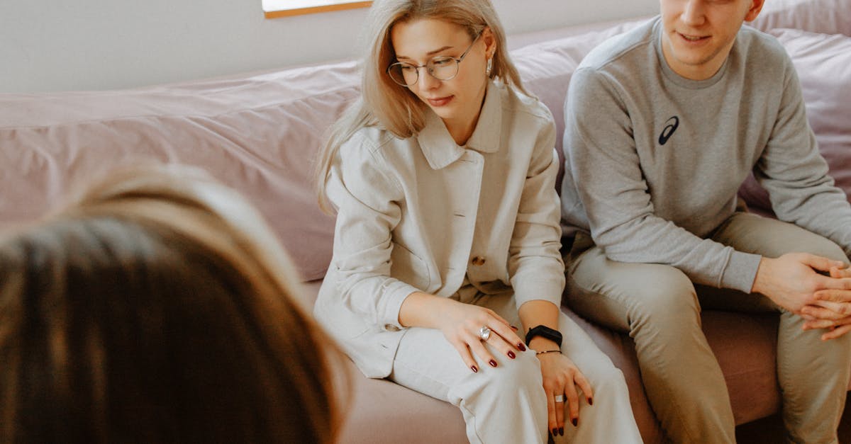 A couple in a counseling session with a therapist in a cozy, modern room.